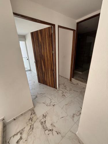 an empty room with a door and a marble floor at Casa a Pie de Playa in Acapulco