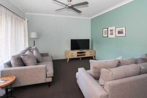 a living room with two couches and a flat screen tv at Blue Retreat in Geographe