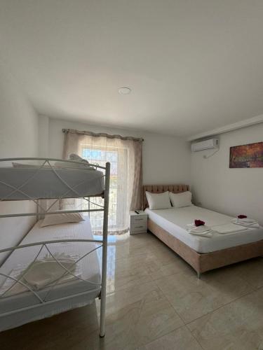 a bedroom with two bunk beds and a window at Villa Festim Ksamil in Ksamil