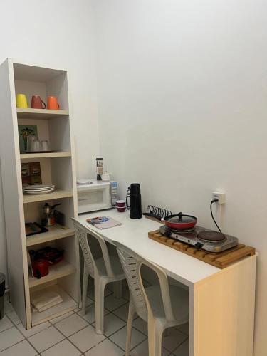 een keuken met een aanrecht met stoelen en een tafel bij Manaira Suite 03 com 2 camas de solteiro ou 1 de casal in João Pessoa
