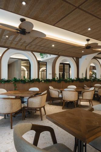 a dining room with tables and chairs and a ceiling at Hygge Hotel and Villas Seminyak in Seminyak