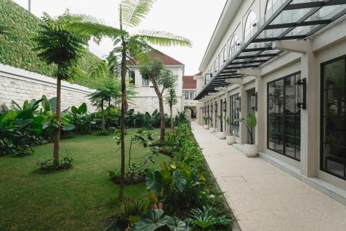 a courtyard of a building with trees and plants at Hygge Hotel and Villas Seminyak in Seminyak