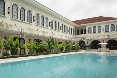 a swimming pool in the courtyard of a building at Hygge Hotel and Villas Seminyak in Seminyak