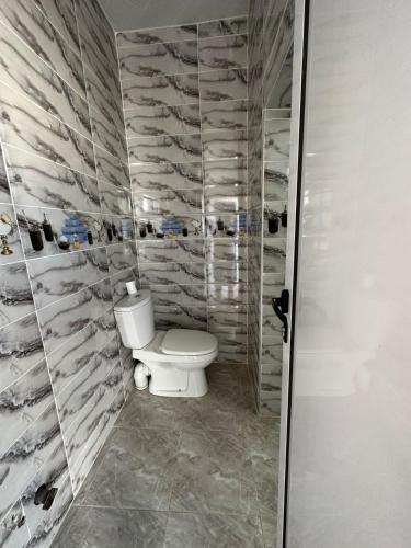 a bathroom with a white toilet in a room at Villa De Compagne 