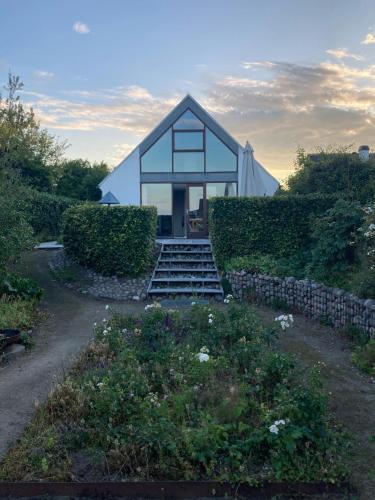 a small white house with a staircase leading to it at Beach House With Sauna By Norsminde Harbour in Malling