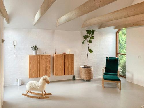a room with a rocking sheep and a green chair at Beach House With Sauna By Norsminde Harbour in Malling