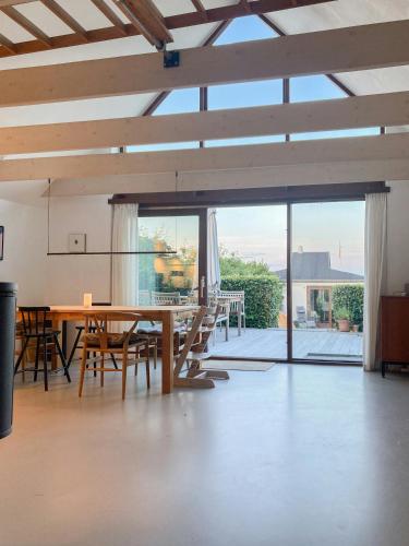 a dining room with a table and chairs and a large window at Beach House With Sauna By Norsminde Harbour in Malling