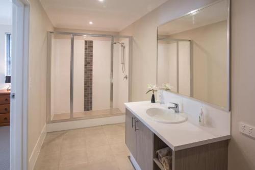 a white bathroom with a sink and a shower at Marina Family Beachscape in Geographe