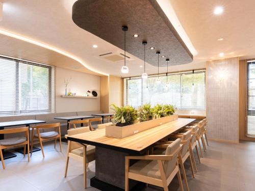 a dining room with tables and chairs and windows at Super Hotel Premier Toyama Castle Park in Toyama