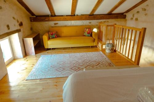 a bedroom with a yellow couch and a rug at La casa de los árboles in Isla
