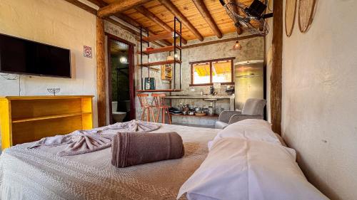 a bedroom with a bed and a tv on a wall at Pousada Reserva Setiba Guarapari in Guarapari