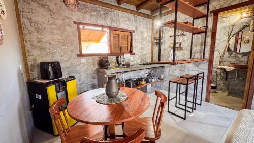 a kitchen with a table and chairs in a room at Pousada Reserva Setiba Guarapari in Guarapari