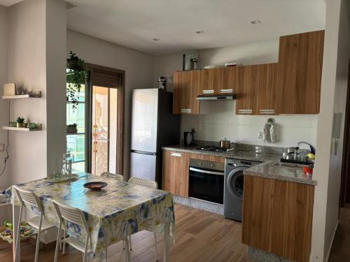 a kitchen with a table and a counter top at Appartement vue piscine - Pour Famille - Blue Beach SIDI RAHAL in Sidi Rahal