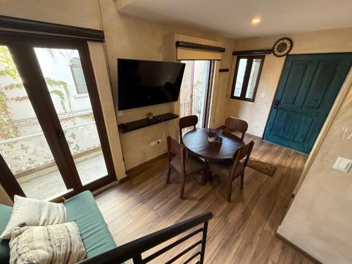 a living room with a table and a television at Loft Nizza en ValQuirico a 50 mts Plaza del Zocalo in Santeagueda