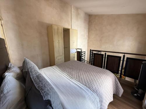 a bedroom with a white bed and a cabinet at Loft Nizza en ValQuirico a 50 mts Plaza del Zocalo in Santeagueda