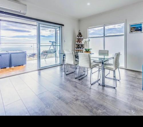 a dining room with a glass table and chairs at Ocean Front retreat Fleurieu Coast Wirrina Cove in Wirrina Cove