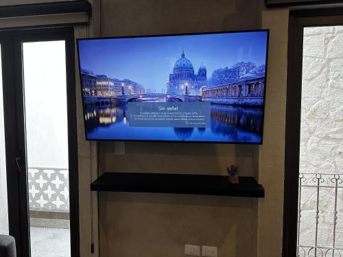 a flat screen tv hanging on a wall at Loft Nizza en ValQuirico a 50 mts Plaza del Zocalo in Santeagueda