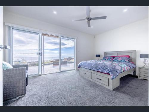 a bedroom with a bed and a view of the ocean at Ocean Front retreat Fleurieu Coast Wirrina Cove in Wirrina Cove