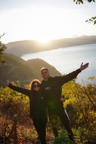 a man and a woman standing on top of a mountain at Bee Fresh Camping y Mirador in Santa Cruz La Laguna