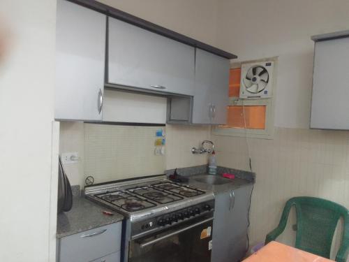 a small kitchen with a stove and a sink at شقه فندقيه in Sheikh Zayed