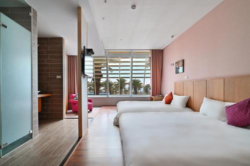 a hotel room with two beds and a window at In Young Hotel in Kaohsiung