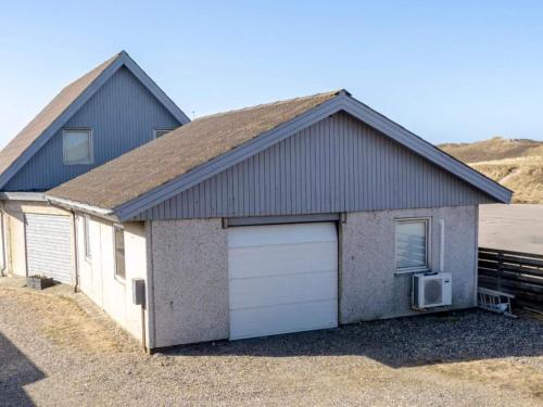 a large house with a garage with a car at 6 person holiday home in Vestervig in Vestervig
