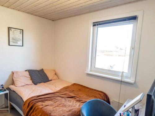 a small bedroom with a bed and a window at 6 person holiday home in Vestervig in Vestervig