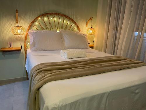 a bedroom with a large bed with a wooden headboard at Casa Mar III in João Pessoa