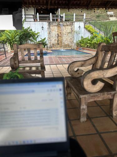 a laptop computer sitting next to two wooden benches at La Gloria Ranch 
