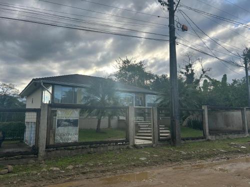 a house with a fence in front of it at Recanto do sossego!! in Morretes