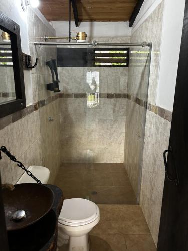 a bathroom with a shower with a toilet and a sink at La Gloria Ranch 