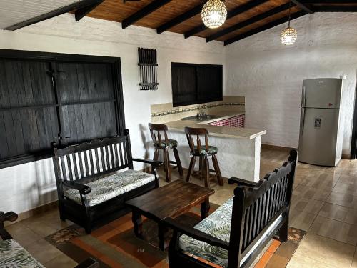 a kitchen with wooden chairs and a table and a refrigerator at La Gloria Ranch 