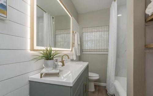 a white bathroom with a sink and a toilet at Retreat on the Bayou in Port Richey