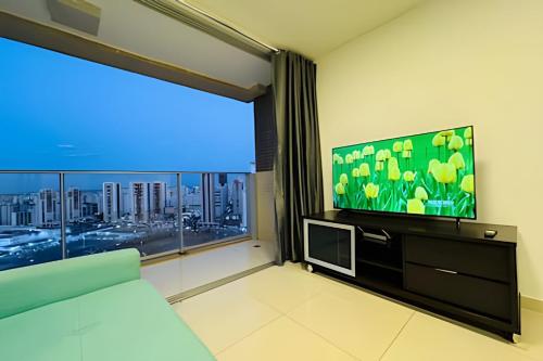 a living room with a large window and a television at Apt Luxo VI no Shopping Df Plaza in Brasilia