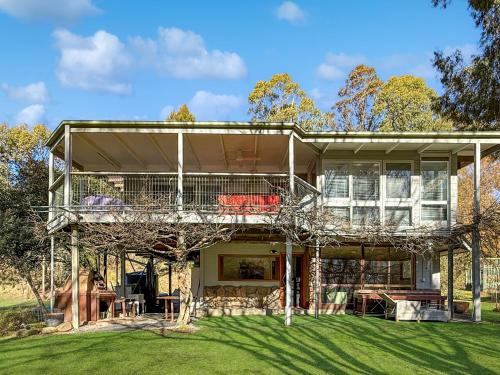an exterior view of a house with a balcony at River Flat in Merrijig