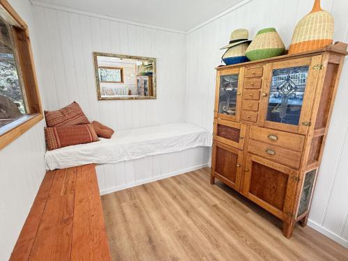 a small room with a bed and a dresser at River Flat in Merrijig