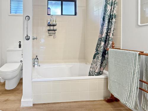 a bathroom with a tub and a toilet at River Flat in Merrijig