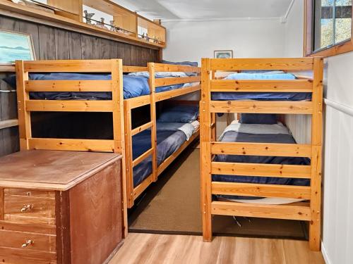 a room with two bunk beds and a desk at River Flat in Merrijig