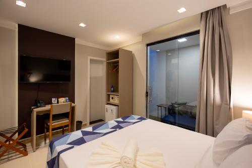a bedroom with a bed and a sliding glass door at Aira Hotel in Sobral