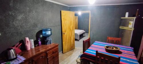a kitchen with a table and a room with a bedroom at Casa Esquina in Tafí Viejo