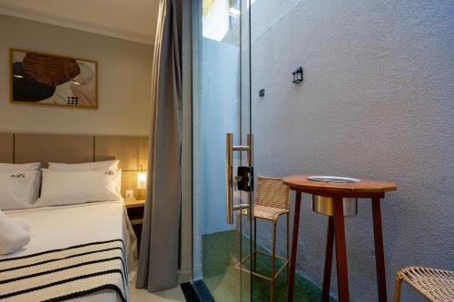 a bedroom with a bed and a small table at Aira Hotel in Sobral