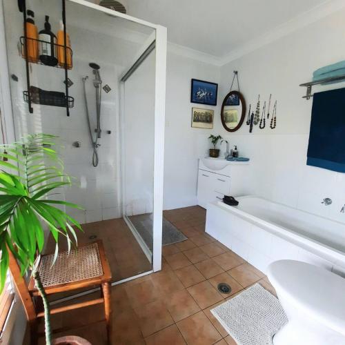 a bathroom with a shower and a tub and a sink at Misty River in Macksville