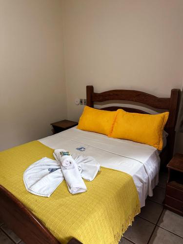a bedroom with a bed with towels on it at Pousada Sanhaço in Abraão