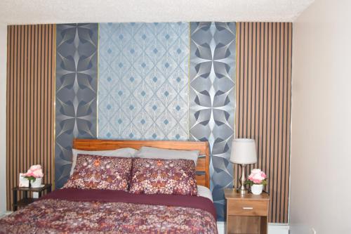 a bedroom with a bed and a blue and gray wall at 3BR & 2Bath Bronx Stay-Private Suite-Parking in Bronx