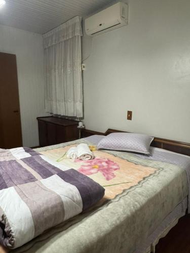 a bedroom with a bed with a blanket on it at Apartamento espaçoso para locação - Bairro Universitário in Bento Gonçalves