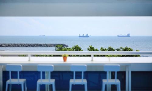 a view of the ocean from a bar with stools at In Young Hotel in Kaohsiung