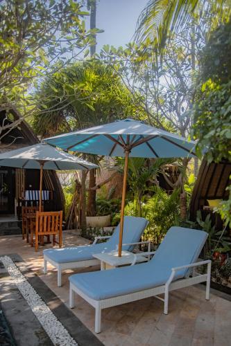 a group of chairs and umbrellas on a patio at Villa Tahid in Gili Air