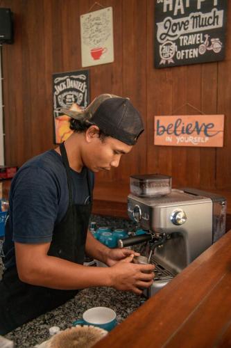 a man is standing at a coffee machine at Villa Tahid in Gili Air