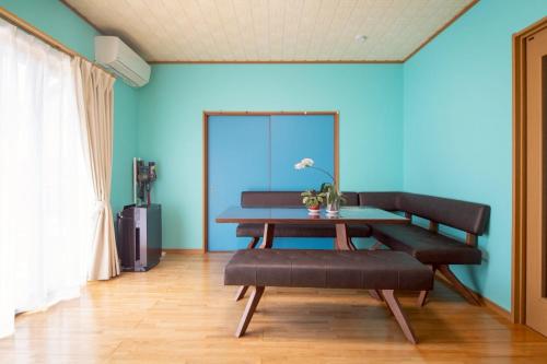 a blue room with a bench and a table at Nagata House in Ise