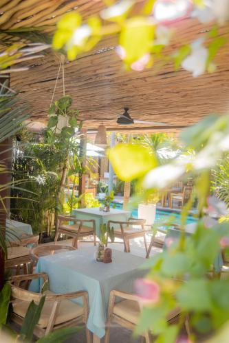 a patio with two tables and chairs and plants at Villa Tahid in Gili Air